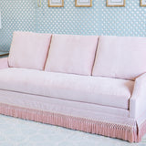 Velvet Pink Sofa with pink fringe and a scallop arm