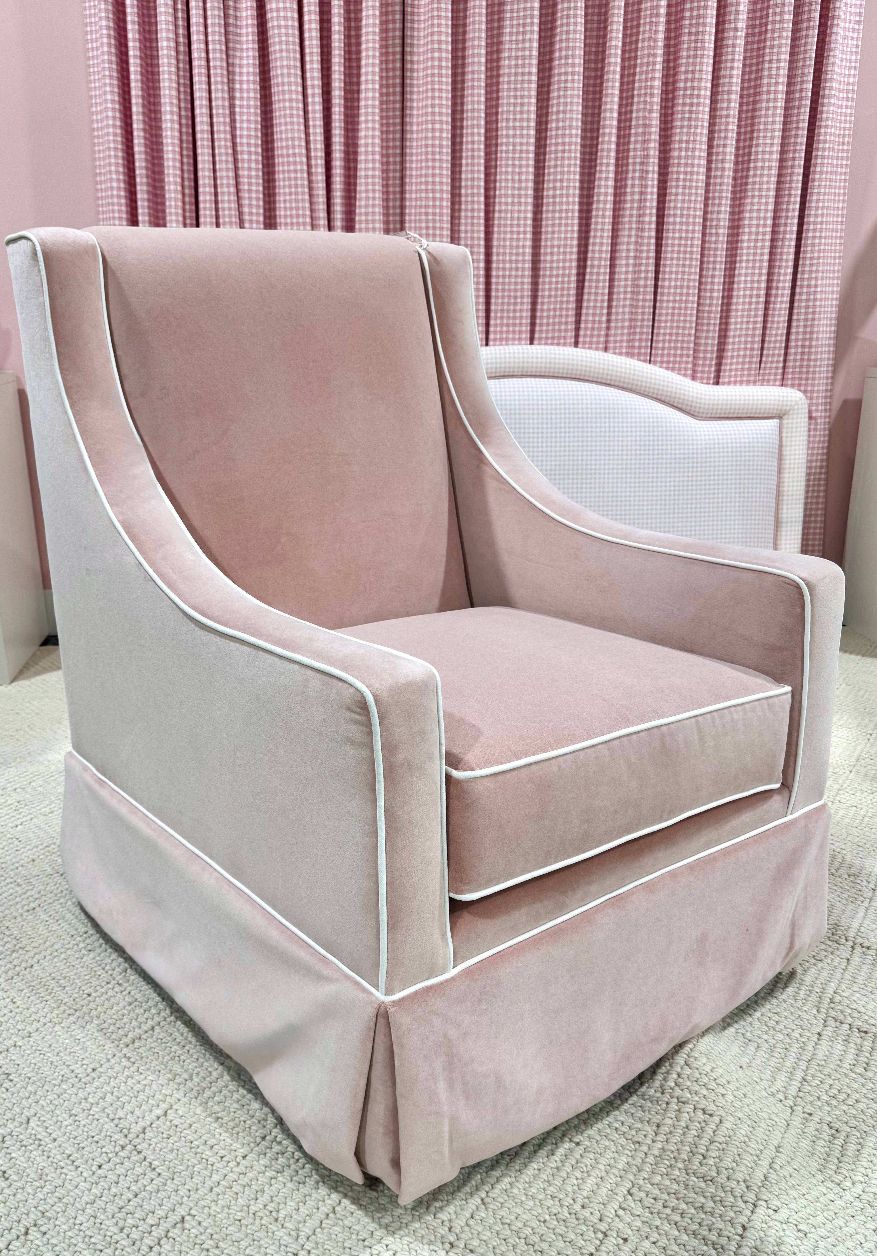 Pink velvet rocker in a room with pink curtains.